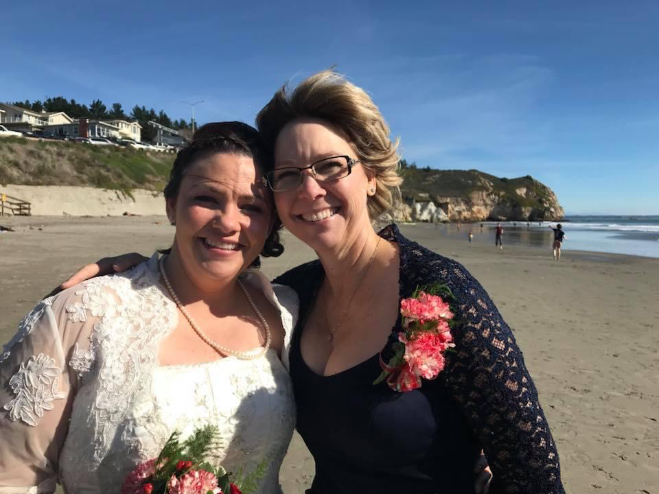 Dani (mother of the bride) and daughter in wedding dress at the beach