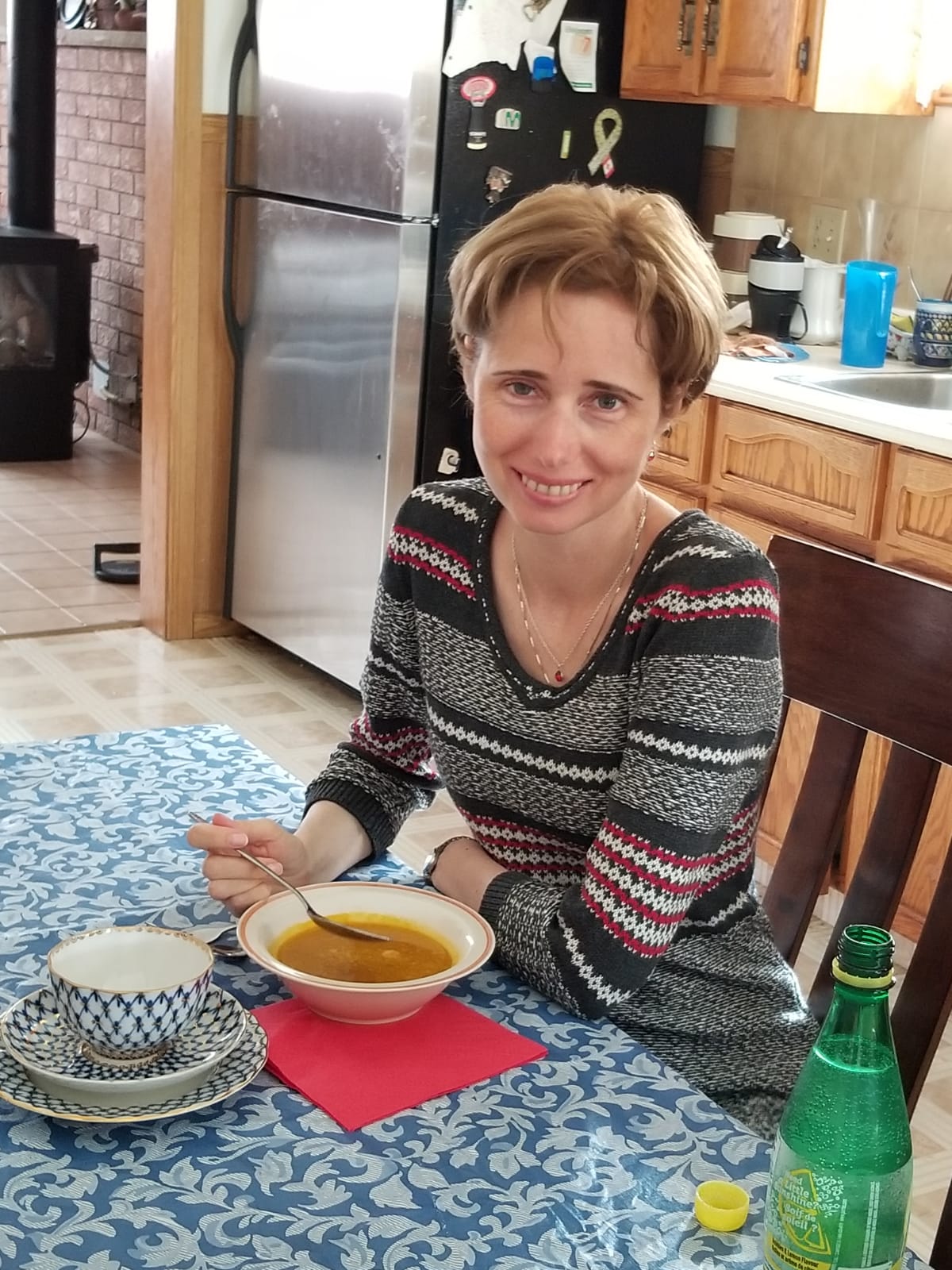 Elena seated at kitchen table with a bowl of soup 