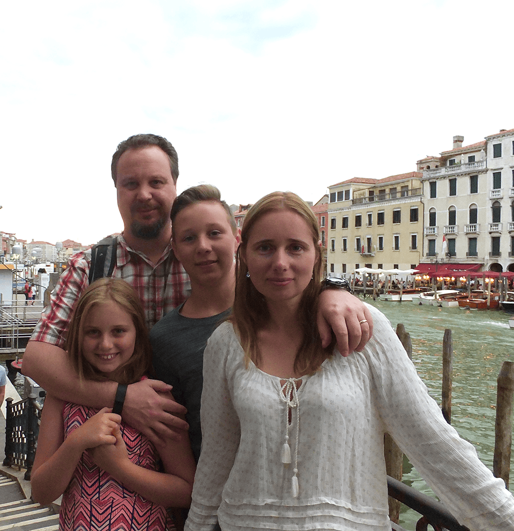 Elena, Don and their two children in a city with a canal in background
