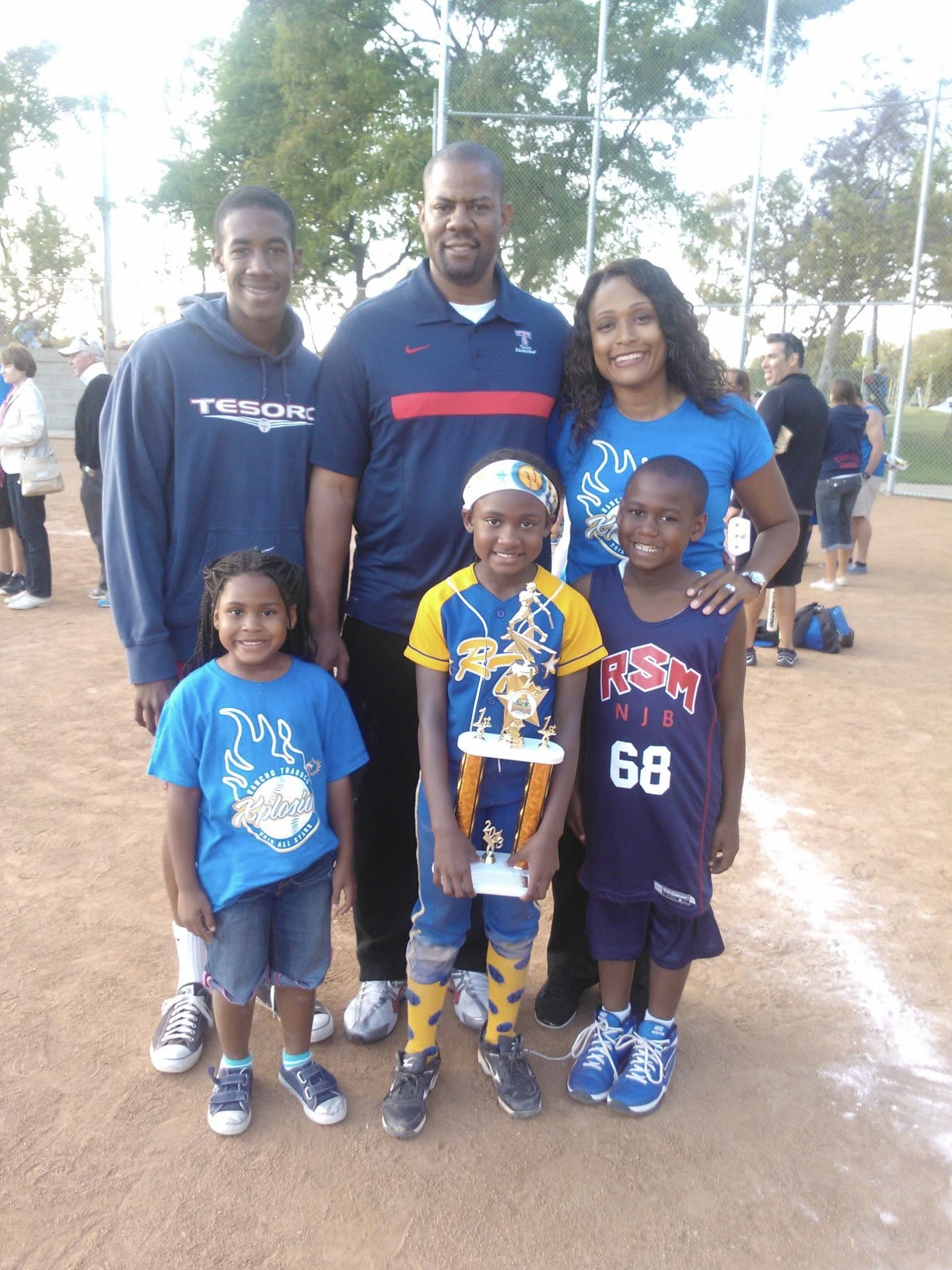 A young Maya holds her softball  trophy in this family photo